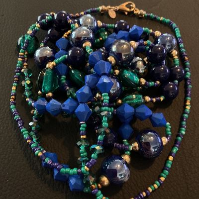 Sale Photo Thumbnail #207: Multi-strand long statement necklace featuring a vibrant mix of royal blue, teal green, purple, and gold-tone beads, including faceted, iridescent, and seed beads. Includes a lobster claw clasp and a small hangtag stamped with the Chico's logo. Shows mino