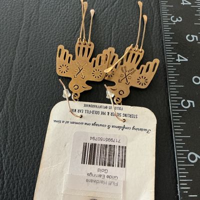 Sale Photo Thumbnail #139: Pair of Fluff Hardware 'Glide' dangle earrings featuring a brass or gold-tone Thunderbird design with hammered tail strands. Includes original carding which notes 14k gold-filled or sterling silver ear wires. Measure approximately 3 inches in overall leng
