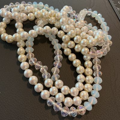 Sale Photo Thumbnail #206: A long vintage beaded strand featuring cream-colored faux pearls alternating with faceted iridescent crystal glass beads and pale blue faceted glass beads. The strand appears continuous/flapper style without a clasp. Shows light vintage wear appropriate f