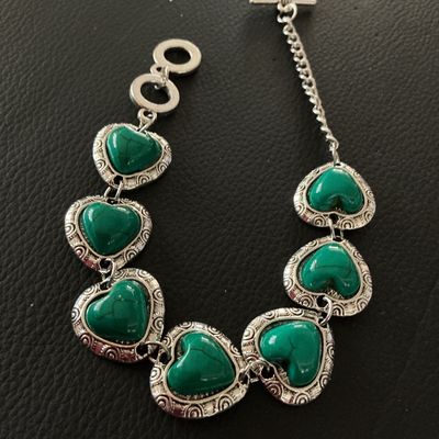 Sale Photo Thumbnail #124: Silver-tone link bracelet featuring six heart-shaped green stone or resin cabochons with faux turquoise veining, set in textured silver-tone heart borders. Finished with an adjustable toggle clasp and extension chain. Measures approximately 8 inches in to