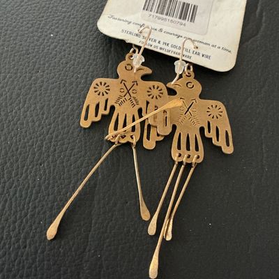 Sale Photo Thumbnail #140: Pair of Fluff Hardware 'Glide' dangle earrings featuring a brass or gold-tone Thunderbird design with hammered tail strands. Includes original carding which notes 14k gold-filled or sterling silver ear wires. Measure approximately 3 inches in overall leng