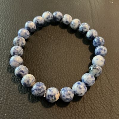 Sale Photo Thumbnail #218: Beaded stretch bracelet featuring polished blue and white mottled stone beads (resembling sodalite or gemstone material). Good condition with no visible damage.