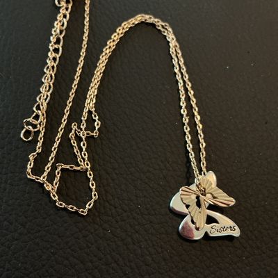 Sale Photo Thumbnail #178: A silver-tone cable chain necklace featuring a layered butterfly pendant engraved with the word 'Sisters'. Includes an extender chain with a lobster claw clasp. Appears to be in good pre-owned condition with light surface wear.