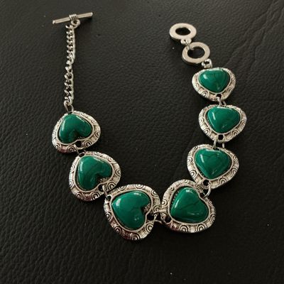 Sale Photo Thumbnail #125: Silver-tone link bracelet featuring six heart-shaped green stone or resin cabochons with faux turquoise veining, set in textured silver-tone heart borders. Finished with an adjustable toggle clasp and extension chain. Measures approximately 8 inches in to