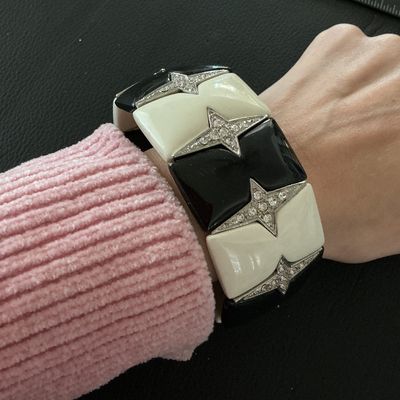 Sale Photo Thumbnail #123: Bold Art Deco style stretch cuff bracelet featuring alternating black and off-white enamel tiles accented with rhinestone-paved four-point stars. Meant to slide easily over the wrist. Measures approximately 2 inches wide. Shows minor surface wear, overall