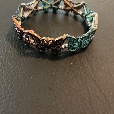Sale Photo Thumbnail #210: Costume stretch bracelet featuring alternating butterfly links in verdigris green patina, copper-tone, and silver-tone finishes with small silver-tone spacer beads. Elastic band design allowing for flexible sizing. Shows light wear consistent with pre-own