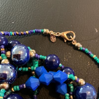 Sale Photo Thumbnail #208: Multi-strand long statement necklace featuring a vibrant mix of royal blue, teal green, purple, and gold-tone beads, including faceted, iridescent, and seed beads. Includes a lobster claw clasp and a small hangtag stamped with the Chico's logo. Shows mino
