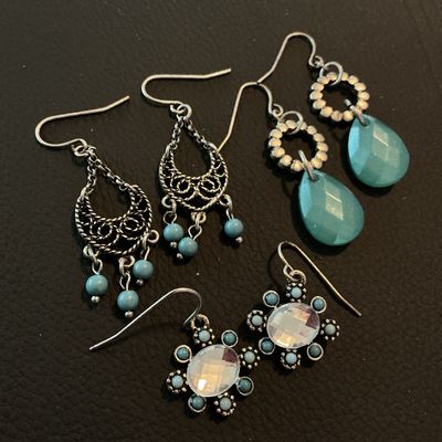 Sale Photo Thumbnail #216: A lot of three pairs of silver-tone French wire dangle earrings featuring Southwestern-inspired designs. Includes one pair of filigree chandelier earrings with turquoise-blue beads, one pair featuring faceted teal teardrops, and one pair featuring central