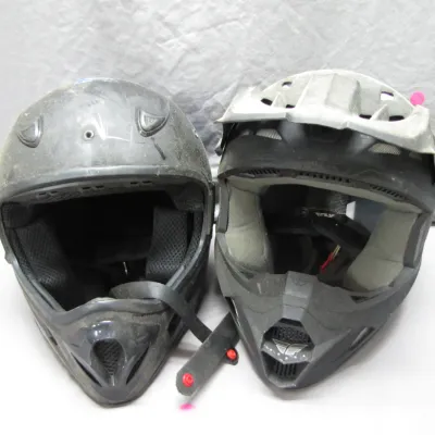 Sale Photo Thumbnail #150: Pair of used black motocross and off-road dirt bike helmets, showing surface wear and scuffs.