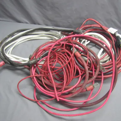 Sale Photo Thumbnail #263: Assortment of heavy-duty electrical wire and battery cables, including red, white, and black insulated leads with terminal lugs.