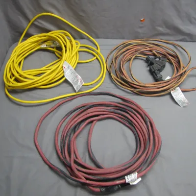 Sale Photo Thumbnail #36: Collection of three heavy-duty outdoor extension cords, including one bright yellow cord, one red cord, and one orange cord with a three-outlet adapter splitter.