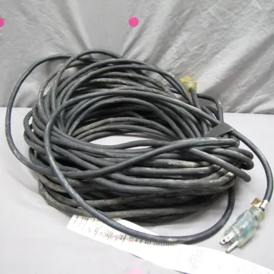 Sale Photo Thumbnail #60: Heavy-duty coiled black extension cord featuring a clear illuminated male plug end and safety warning label attached.