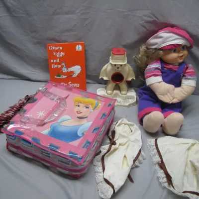 Sale Photo Thumbnail #51: Collection of children's items including a vintage My Child doll in purple overalls, a Dr. Seuss Green Eggs and Ham book, a vintage Snoopy motorized pencil sharpener, a Disney Cinderella play mat set, and lace bonnets.