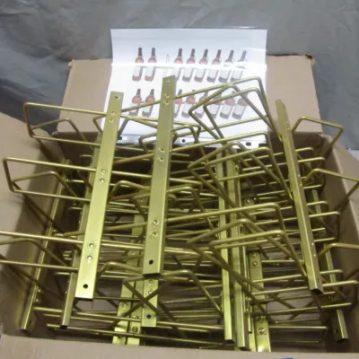 Sale Photo Thumbnail #302: Box of gold-toned metal wall-mounted wine rack components with assembly instructions sheet.