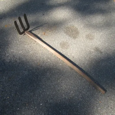 Sale Photo Thumbnail #139: Vintage garden manure or pitch cultivator fork featuring a forged four-tine steel head and a long wooden handle.