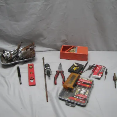 Sale Photo Thumbnail #47: Assorted workshop hand tools and drill accessories, including a red torpedo level, needle-nose pliers, drill bit sets, hole saws, and a long extension bit.