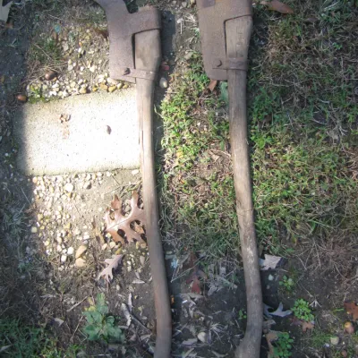 Sale Photo Thumbnail #138: Pair of antique brush axes with long wooden handles and rusted forged steel hooked blades.