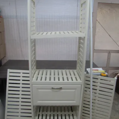 Sale Photo Thumbnail #248: Off-white slatted wooden storage tower featuring open shelving, a single center drawer, and detachable side panels.