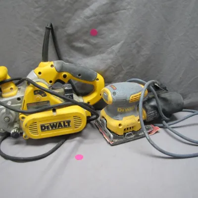 Sale Photo Thumbnail #73: Two corded DeWalt electric sanders, including a heavy-duty belt sander and a palm sander with dust collector bag, both showing signs of light workshop use.