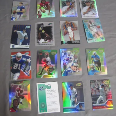 Sale Photo Thumbnail #29: Collection of modern sports trading cards featuring football, baseball, and basketball players, including holographic Topps inserts.