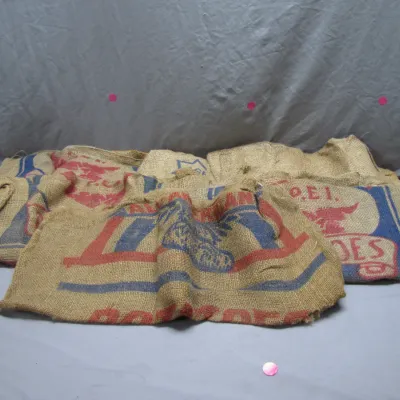 Sale Photo Thumbnail #70: Collection of vintage burlap potato sacks, featuring printed graphics including 'P.E.I. Potatoes'.