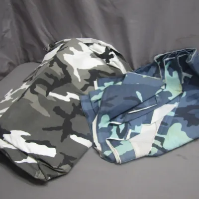 Sale Photo Thumbnail #288: Folded camouflage print fabrics, featuring urban grey and blue digital or woodland camouflage patterns.