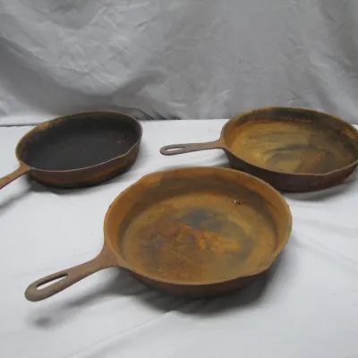 Sale Photo Thumbnail #291: Set of three vintage cast iron skillets showing surface rust and wear, ideal for restoration.