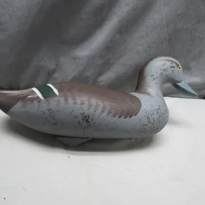 Sale Photo Thumbnail #19: Vintage hand-painted wooden duck decoy featuring painted feather detailing and glass eyes, showing slight surface wear.