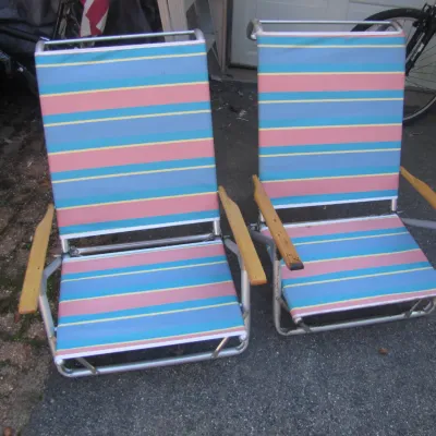 Sale Photo Thumbnail #162: Pair of vintage folding beach chairs with pastel striped canvas and wooden armrests.