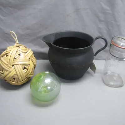 Sale Photo Thumbnail #84: Collection of decorative items including a woven rattan orb, a green glass float orb, a matte black iron pitcher, and a clear glass wire-bail canning jar.