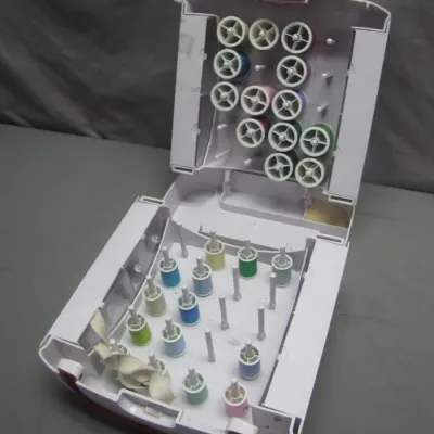 Sale Photo Thumbnail #282: Portable plastic thread spool caddy containing various colored spools of thread.