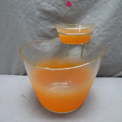 Sale Photo Thumbnail #119: Vintage mid-century chip and dip set featuring frosted orange and clear glass bowls with gold trim, connected by a metal bracket.
