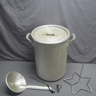 Sale Photo Thumbnail #130: Vintage outdoor aluminum turkey fryer pot set, including a lid, skimmer spoon, thermometer probe, and star-shaped poultry rack.