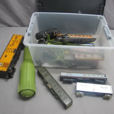 Sale Photo Thumbnail #256: Collection of vintage model train cars, accessories, and a plastic storage bin filled with additional train parts.
