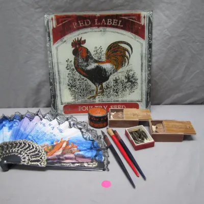 Sale Photo Thumbnail #102: Vintage Red Label Poultry Feed glass sign displayed alongside a lace-trimmed folding fan, dip pens with spare nibs, and small wooden trinket boxes.