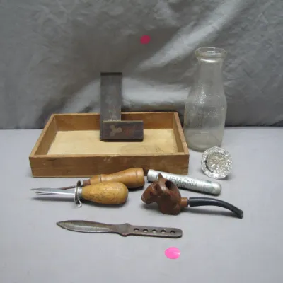 Sale Photo Thumbnail #215: Collection of vintage oddities including a carved horse-head smoking pipe, clear glass milk bottle, glass doorknob, small hand tools, try square, and a wooden tray.