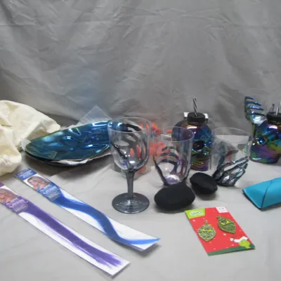 Sale Photo Thumbnail #231: Collection of Halloween and novelty items, including iridescent skull cups, skeleton hand glassware, colorful hair extensions, and Grinch earrings.