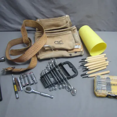 Sale Photo Thumbnail #96: Assortment of hand tools including a CLC leather tool belt, hammer, wrench set, socket set, DeWalt bit set, and wood carving chisels.