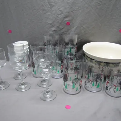 Sale Photo Thumbnail #101: Collection of holiday drinkware including clear stemmed goblets, printed winter scene tumblers with snowmen and evergreen trees, and a matching serving bowl.