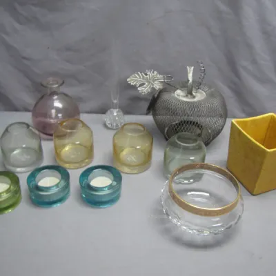 Sale Photo Thumbnail #82: Collection of decorative glassware and tabletop items, including colorful votive candle holders, small vases, a mesh pumpkin accent piece, and a yellow planter.