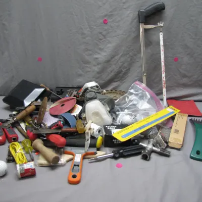 Sale Photo Thumbnail #190: Assorted lot of hand tools and workshop supplies, including screwdrivers, a hacksaw, a respirator mask, tape, and hardware.