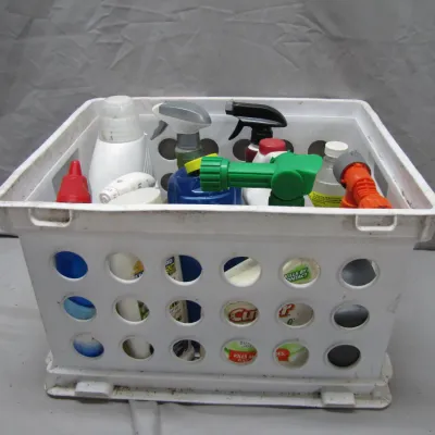 Sale Photo Thumbnail #69: White plastic storage crate filled with assorted household cleaning supplies, lawn chemical sprays, and garden hose nozzles.