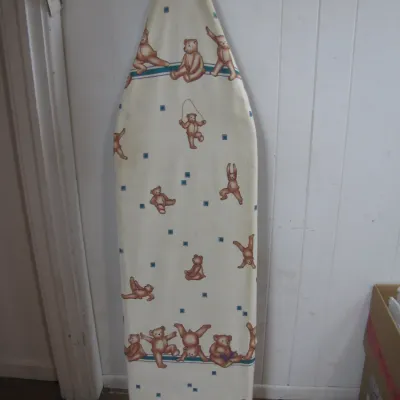 Sale Photo Thumbnail #201: Foldable metal ironing board featuring a fabric cover printed with illustrations of playful teddy bears.