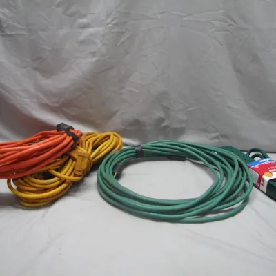 Sale Photo Thumbnail #225: Collection of heavy-duty outdoor extension cords in orange, yellow, and green, alongside an Ace brand power strip.