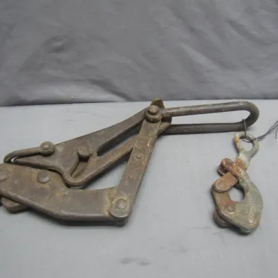 Sale Photo Thumbnail #273: Vintage heavy-duty cast iron wire stretcher tool with attached cable grip clamp, showing heavy patina and age-related rust.