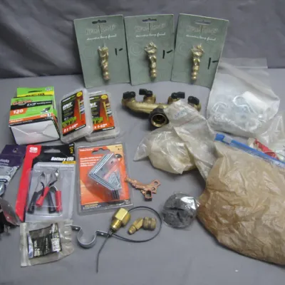 Sale Photo Thumbnail #281: Assortment of hardware and home improvement items, including decorative lamp finials, battery clips, sanding belts, screws, and brass hose fittings.