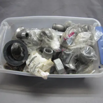 Sale Photo Thumbnail #91: Clear plastic storage tote filled with various pipe fittings, elbows, connectors, and hardware components.