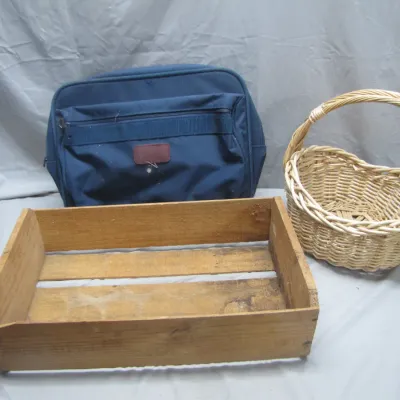 Sale Photo Thumbnail #294: Collection of storage items including a blue soft-sided luggage bag, a wooden slatted crate, and a woven wicker basket with handle.