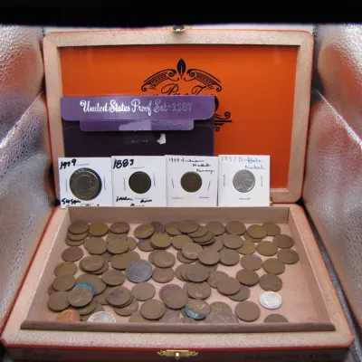 Sale Photo Thumbnail #8: Collection of US coins presented in a wooden cigar box, including loose Wheat pennies, individual flips featuring an 1883 and 1898 Indian Head penny, a 1937 Buffalo nickel, and a 1987 United States Proof Set.