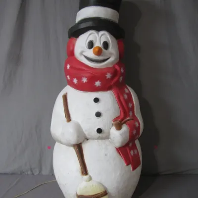 Sale Photo Thumbnail #151: Vintage plastic snowman blow mold Christmas decoration featuring a black top hat, red scarf with white stars, and holding a broom.